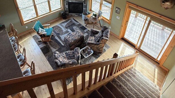 A cabin interior with a stone fireplace, wooden ceiling, and deer antlers on the wall. - Quiet, secluded bluff top cabin with beautiful sunsets (Alma)