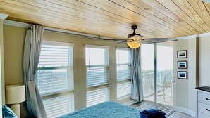A bedroom with a bed, a ceiling fan, a balcony with a chair, and a dresser. - "The Turtle Nest" a 3bed/2 bath Condo in St Regis (New Listing) (North Topsail Beach)