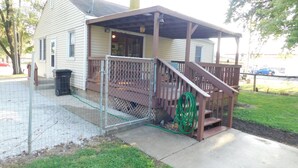 Une maison avec un porche couvert, un escalier et une antenne parabolique.