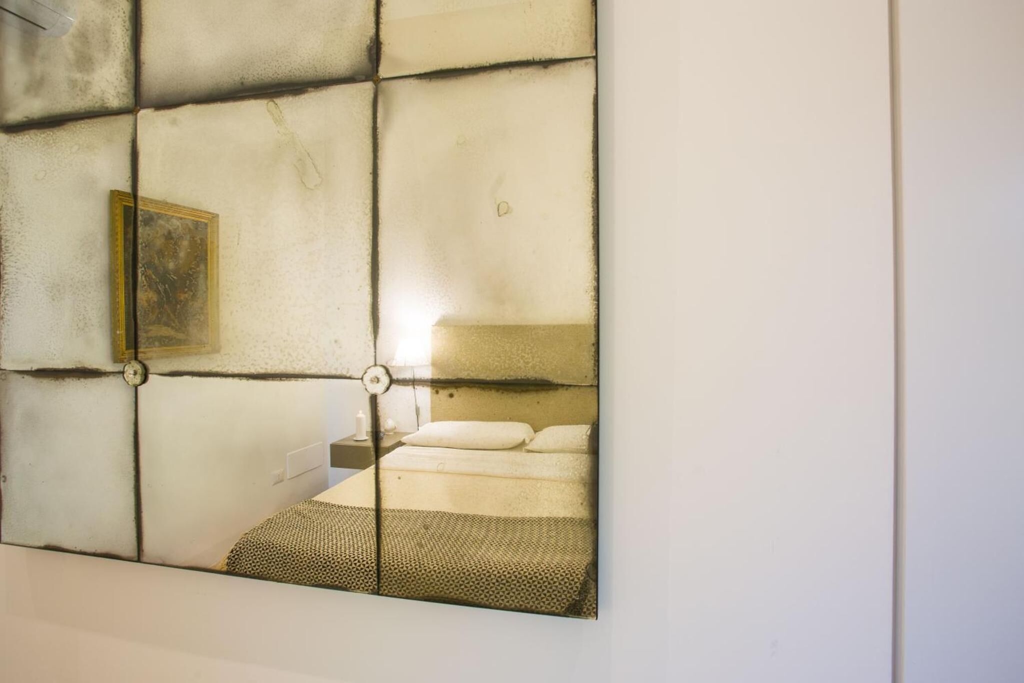 A wall with a grid pattern and a framed picture.