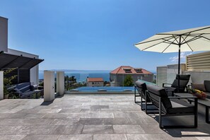 A rooftop terrace with a pool, outdoor seating, and a view of the sea. - Villa Ninona with Heated Pool II (Makarska)