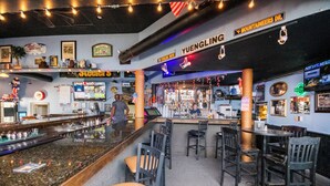 A bar area with a counter, chairs, and a sign reading "YUENGLING". - Spacious 2 bd/2b Arcadian Dunes near Shore Drive, Ocean Annie's, golf & beach (Myrtle Beach)