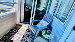 A covered patio with two chairs, a small table, and a rug. - Spacious 2 bd/2b Arcadian Dunes near Shore Drive, Ocean Annie's, golf & beach (Myrtle Beach)