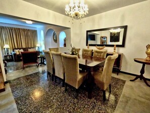 A dining area with a chandelier, a round table, and chairs. - Luxury 2BR/2BA w/ Jacuzzi - Walk to Beach & Castle (Chancay)