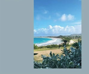 A coastal landscape with a clear sky, a beach, and some vegetation. - A seaview cocoon (Saint martin)