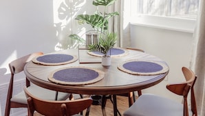 A round dining table with four chairs, a potted plant, and a small table lamp. - Instant Book, Clean & Cozy - minutes to Kalahari (Round Rock)