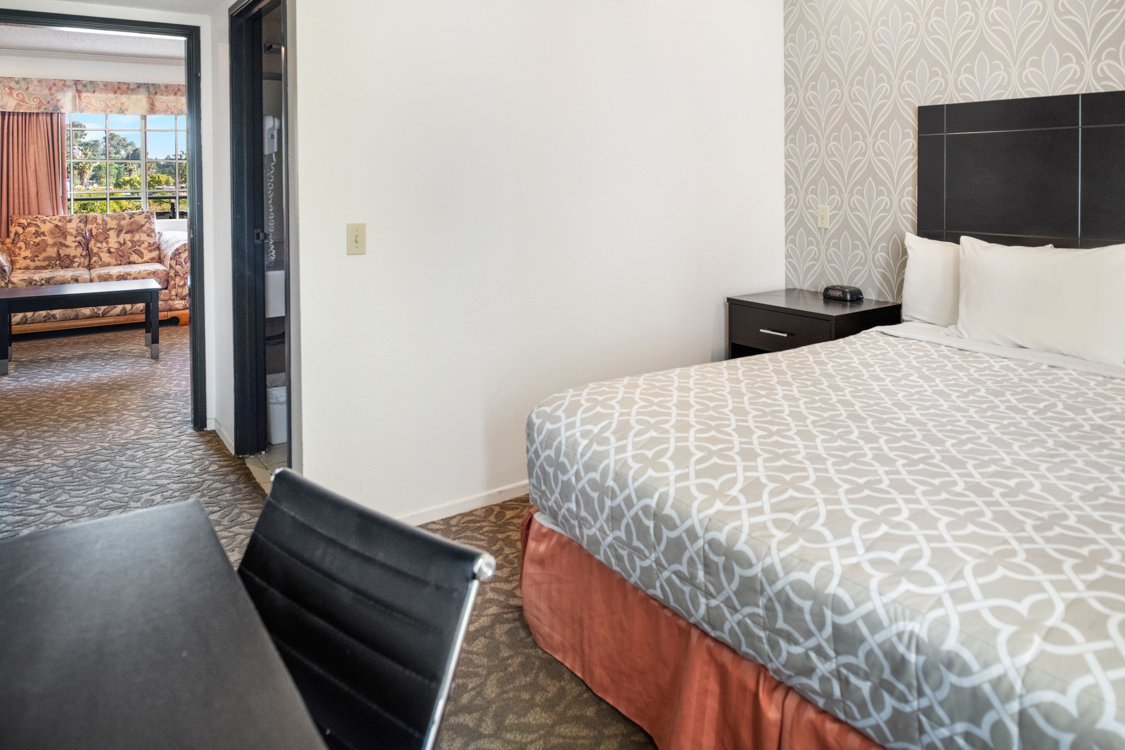 Une chambre d’hôtel avec un lit, une table de chevet, une chaise et une table.