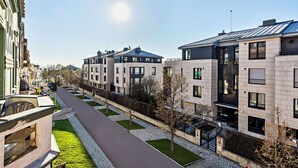 Un moderno edificio residencial con un sendero pavimentado y áreas verdes.