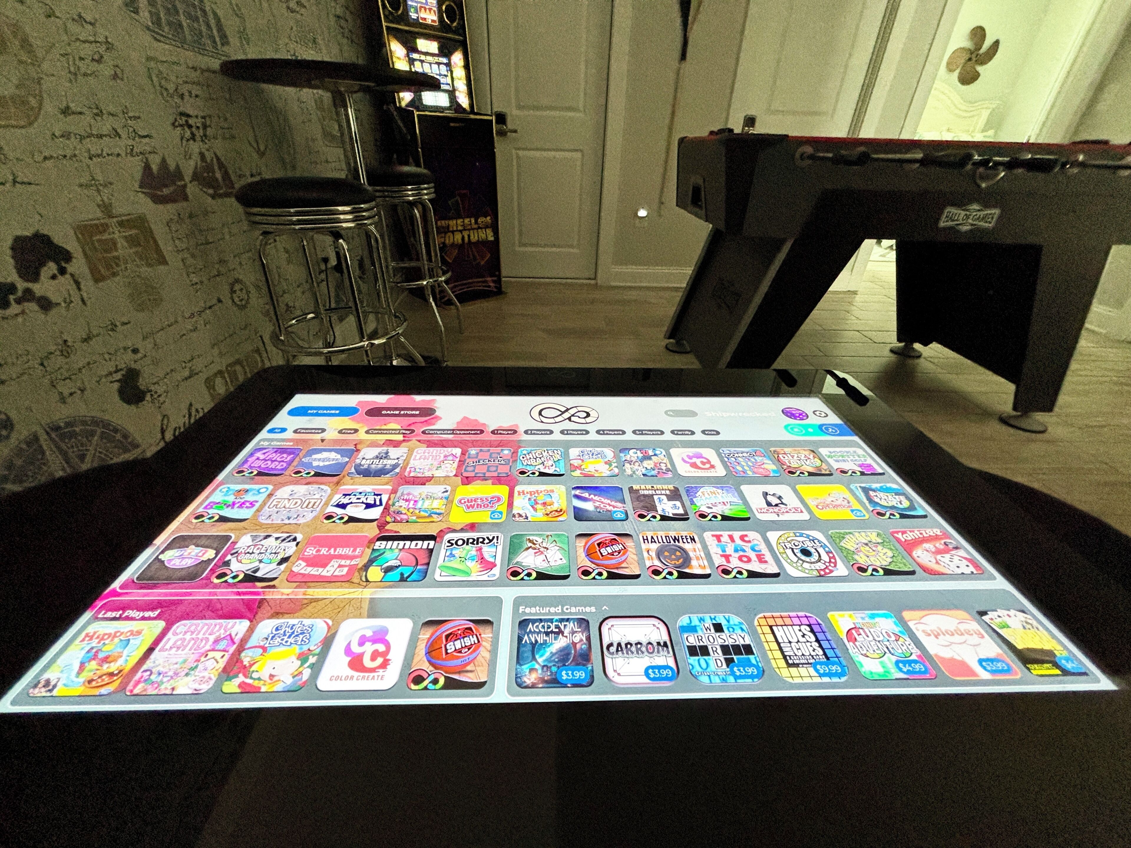 A game board with various game tiles and a pool table in the background.