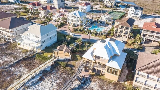 An aerial view of a coastal residential area with multiple houses, a swimming pool, and a beach access walkway. - Ocean Terrace-Large beach house with private pool (Gulf Shores)