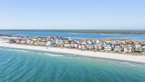 A coastal residential area with houses along the beach, clear skies, and calm sea. - Ocean Terrace-Large beach house with private pool (Gulf Shores)