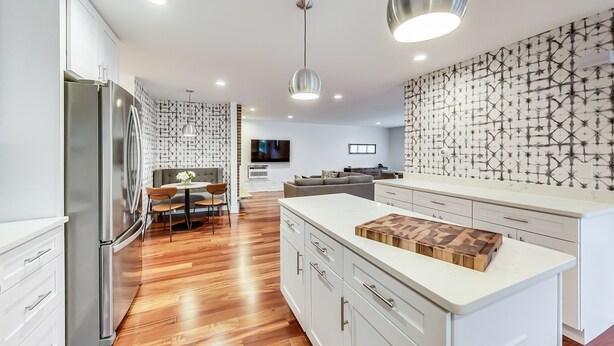 A modern kitchen with a central island, stainless steel appliances, and patterned backsplash. - Oakton St. Inn, Evanston near Northwestern, Loyola and Chicago (Evanston)