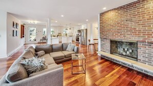 A spacious living area with a large sofa, a glass coffee table, and a fireplace. - Oakton St. Inn, Evanston near Northwestern, Loyola and Chicago (Evanston)