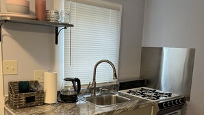 Una cocina compacta con fregadero, estufa y encimera.