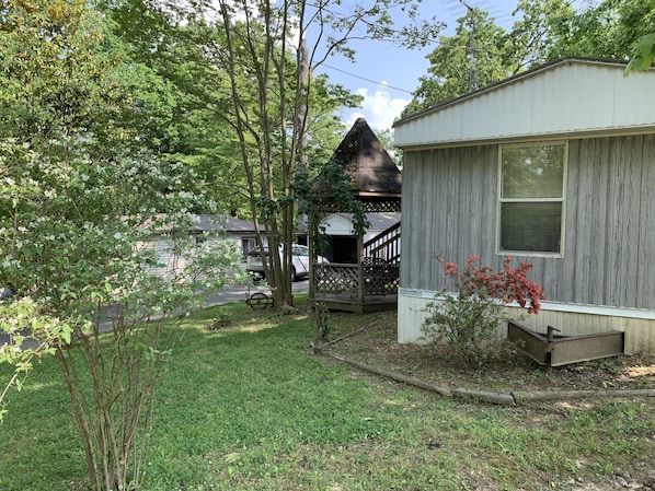 A residential property with a front yard, a wooden house, and a visible garage. - Mobile home. Everything you need. Minutes to water (Springville)