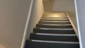 Eine Treppe mit Holzbodenstufen und einer weißen Wand an der Seite.