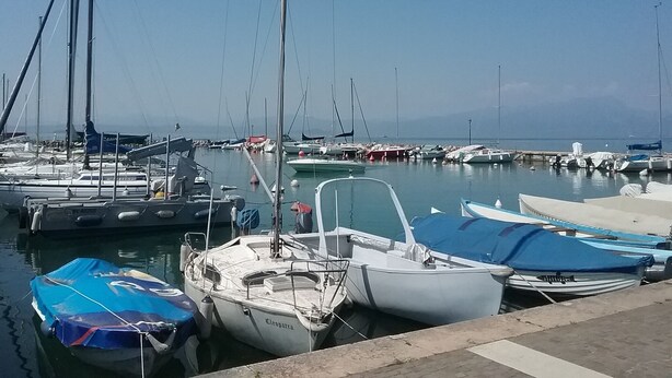 A marina with various boats docked, including sailboats and motorboats. - Simona apartment near Lake Garda and Verona (sona)