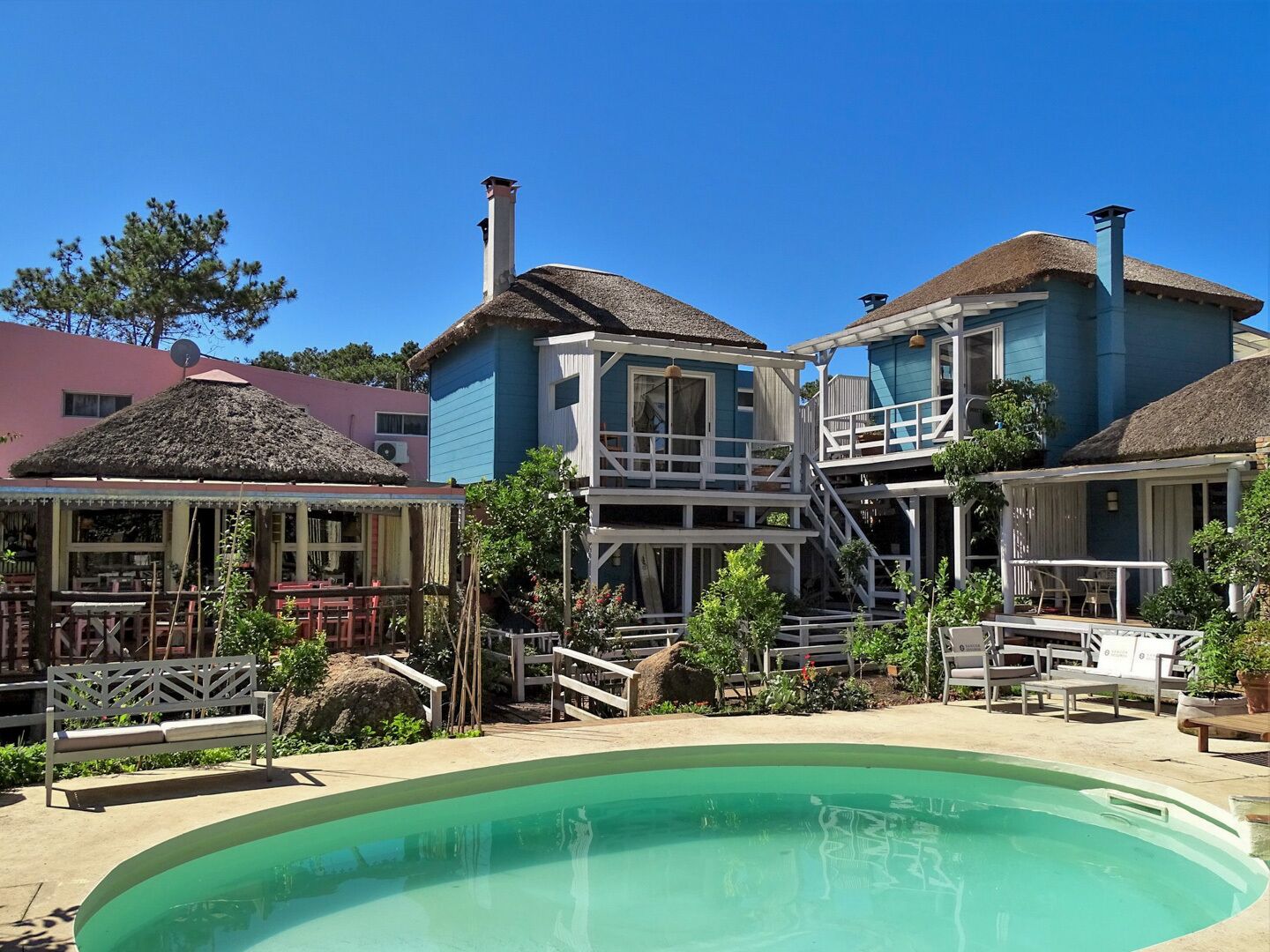 A resort with a swimming pool, multiple buildings with balconies, and outdoor seating areas.