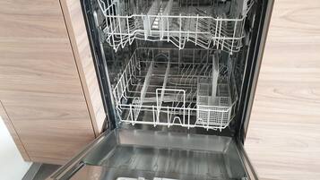 An open dishwasher with multiple racks and a control panel.
