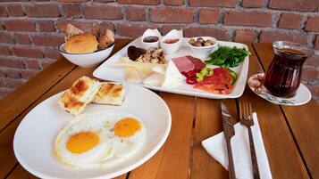 A breakfast setting with a plate of eggs, bread, and a variety of spreads and vegetables.
