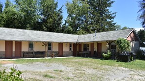 A building with a covered patio area, outdoor seating, and a barbecue grill. - Studio Suite with 2 beds - Located at the Heart of Promised Land State Park  (Greentown)