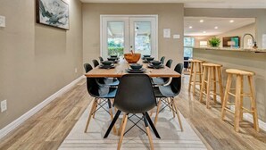 A modern dining area with a wooden table set for six, surrounded by black chairs. - San Antonio Retreat: Pool, Hot Tub & Pickleball (San Antonio)