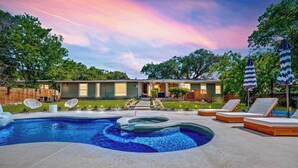 A backyard with a swimming pool, lounge chairs, and a house. - San Antonio Retreat: Pool, Hot Tub & Pickleball (San Antonio)