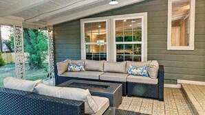 An outdoor patio with a sofa, a coffee table, and a fire pit. - San Antonio Retreat: Pool, Hot Tub & Pickleball (San Antonio)
