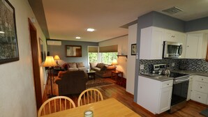 A compact living space with a dining area, kitchen, and seating area. - Sweet 3 Bedroom, Walk to Main St! (Independence)