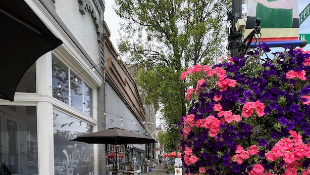 A storefront with outdoor seating, a large flower arrangement, and a street lamp. - Sweet 3 Bedroom, Walk to Main St! (Independence)