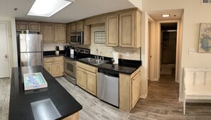 Enjoy cooking in this well-equipped kitchen with a sleek countertop, stainless steel appliances, and ample cabinetry.