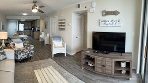 A living room with a sofa, a TV, and a dining area in the background. - Best Views in Orange Beach!!  (Orange Beach)