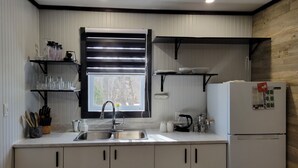 A modern kitchen with a sink, stainless steel appliances, and wooden accents.