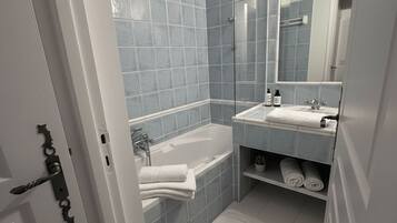 Une salle de bain moderne avec une baignoire, un lavabo et un miroir.
