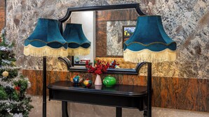 A black console table with a mirror above it, a small Christmas tree, and decorative vases. - Golden Legend Palace Hotel (Hanoi)