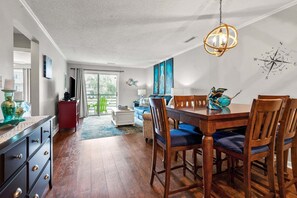 Ein Essbereich mit Holztisch und -stühlen, einem roten Schrank und einem blauen Teppich.