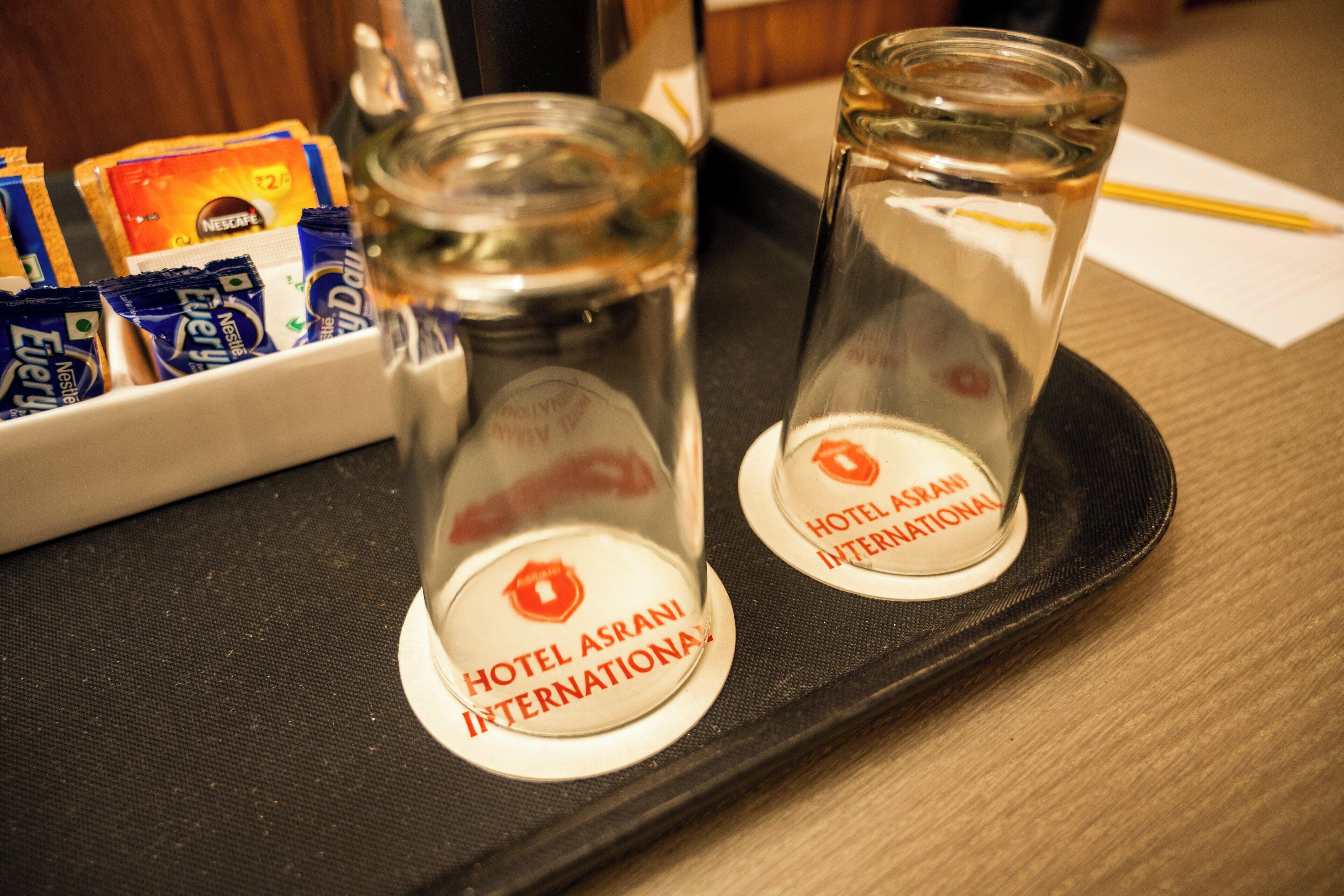 Dos vasos para shots con los logotipos del Hotel Asrani International sobre una bandeja.