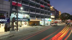 A multi-story hotel with a modern facade, several ground-level shops, and a visible sign for 'Hotel Asran International'. - HOTEL ASRANI INTERNATIONAL (Hyderabad)