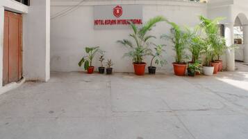 L’entrée d’un hôtel, avec une enseigne indiquant « Hôtel Asrani International » et plusieurs plantes en pot devant.