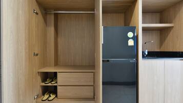 Una cocina moderna con muebles de madera, un refrigerador negro y estantes empotrados.