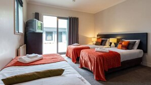 A hotel room with two beds, a large window, and a view of the outside. - Studio 25 - 1 Bedroom place with Pool (Cardrona)