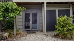 A two-story house with a balcony, a garage, and a front door. - Studio 25 - 1 Bedroom place with Pool (Cardrona)