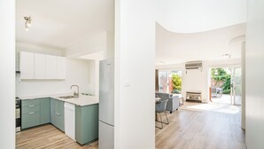 A modern kitchen with white cabinets, a stainless steel refrigerator, and a built-in dishwasher. - Broadwater Beach Villa | Pool, Spa & Tennis (Broadwater)