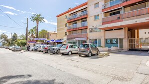 A multi-story building with a row of parked cars in front. - L'Espelido by Interhome (Saint Aygulf)