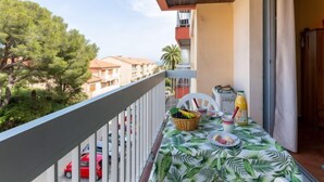 A balcony with a table set for breakfast, overlooking a residential area with trees and buildings. - L'Espelido by Interhome (Saint Aygulf)