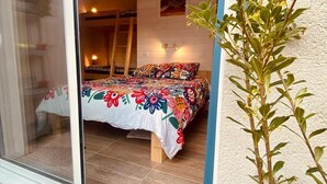 Ein Schlafzimmer mit einem Bett, einer Leiter und einem Fenster.