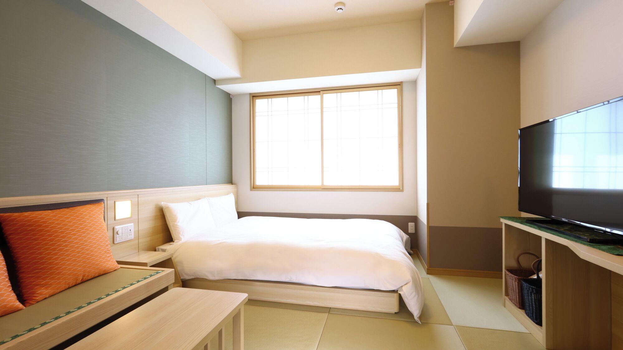 Una habitación de hotel con una cama, un televisor, un escritorio y una ventana.
