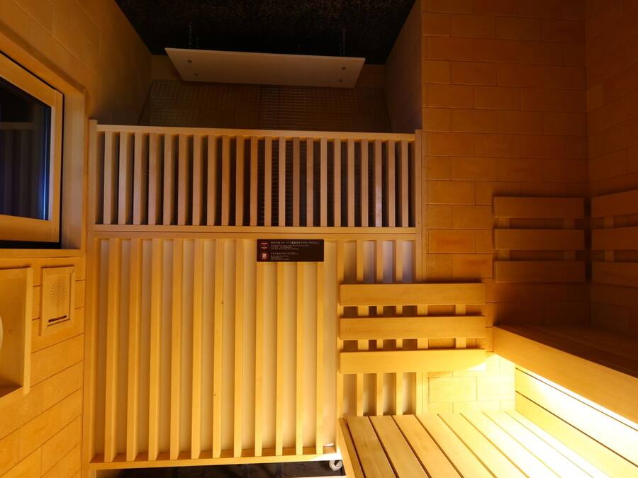 Un sauna con bancos de madera y un reloj.
