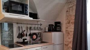 A compact kitchen with a microwave, coffee maker, and various utensils. - Stationery discs, ideal for lovers! (Saint-Laurent-le-Minier)