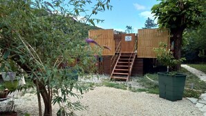 A gravel courtyard with a wooden staircase leading to a wooden structure. - Stationery discs, ideal for lovers! (Saint-Laurent-le-Minier)